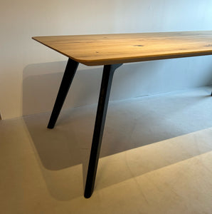 Detailaufnahme der schrägen schwarzen Tischbeine des Nouvion Diva Esstisches, Massivholzplatte Eiche Bianco, Ausstellungsstück im Abverkauf, sofort verfügbar