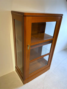 Form Exclusiv Design-Vitrine Premium 1-türig in Kirschbaum, Seitenansicht mit Facettglas, edle Messingbeschläge und eleganter Korpus – Ausstellungsstück in Top-Zustand.