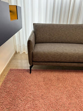 Laden Sie das Bild in den Galerie-Viewer, Modernes Design-Ecksofa Violetta Tilda im Möbelhaus Zeppenfeld, umgeben von Stoffmustern und stilvoller Dekoration.
